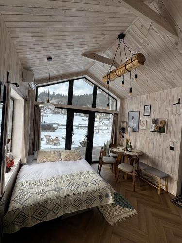 a bedroom with a bed and a table in a room at Osho house Karpaty in Ilʼtsya Dolishna