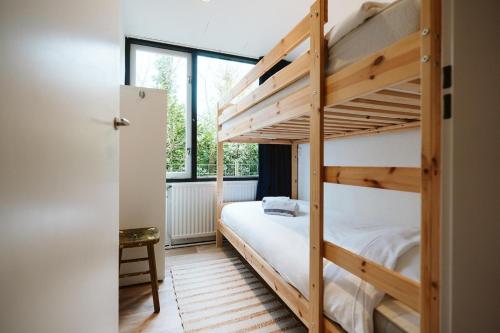 a bedroom with two bunk beds and a window at Jonkerstee 59 - Ouddorp in Ouddorp