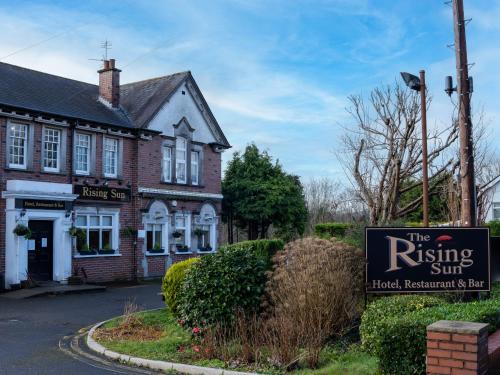 a building with a sign in front of a building at Rising Sun in Rogerstone
