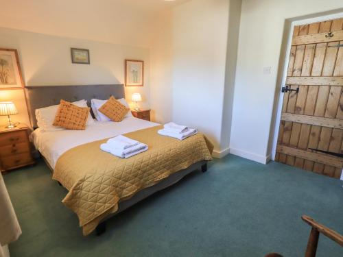 a bedroom with a bed with towels on it at 2 Lupton Hall Cottages in Carnforth