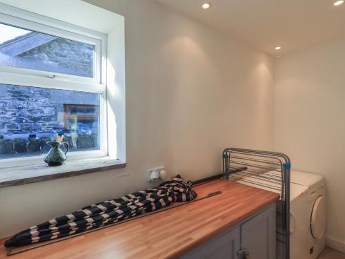 a bed in a room with a window and a mattress at 2 Lupton Hall Cottages in Carnforth