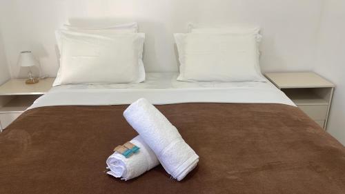 a bed with two rolled towels on top of it at Casa do Val in Fernando de Noronha