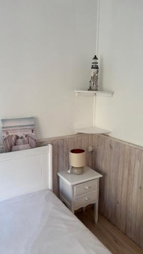 une chambre avec un lit blanc et une table de chevet dans l'établissement Christine, à Notre-Dame-de-Monts