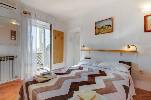 a bedroom with a bed and a large window at Apartments Tasha in Štivan