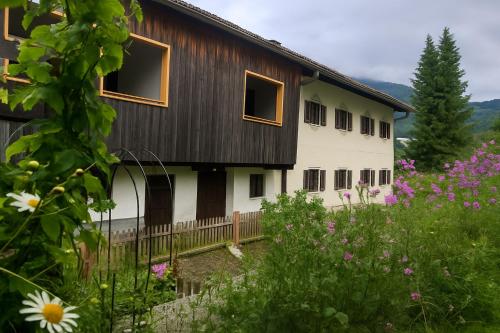a house with a fence and flowers in front of it at Appartements Ehrensberger in Brixen im Thale