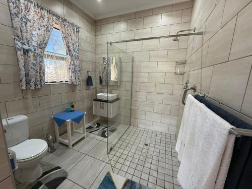 a bathroom with a toilet and a sink at Hettie's Cottage in Hartenbos