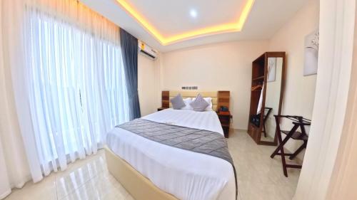 a bedroom with a bed and a large window at Maya Villa in Oyibi