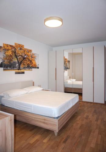 a bedroom with a large bed and a mirror at Colli Apartment Lake Como in Malgrate