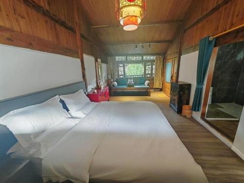 a bedroom with a large white bed in a room at Baisha Holiday Resort Lijiang in Lijiang
