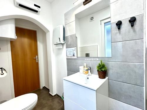 a bathroom with a white toilet and a sink at Rookos rooms in Ljubljana