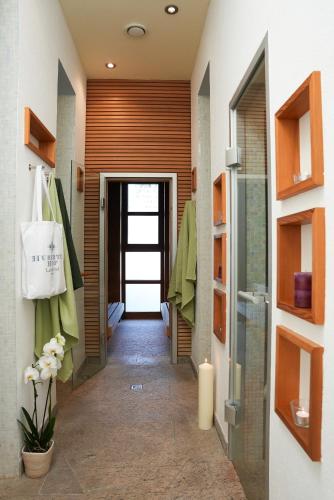 a hallway leading to a bathroom with a door at Hubertus Hof Landhotel in Balatonfenyves