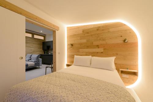 a bedroom with a bed with a wooden wall at Killarney Glamping - Ross Road in Killarney