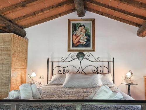 a bedroom with a large bed with a painting on the wall at Podere Raggio Di Sole in San Gimignano