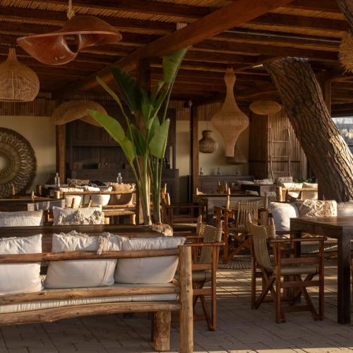 a restaurant with wooden tables and chairs and a cafeteria at NOMAD ARGENTARIO - Area Sosta Camper - NO TENDE - NO CARAVAN - Empty Pitch Only Campervan RV - SOLO PIAZZOLA PER IL PROPRIO CAMPER - Tariffa fino a 4 persone - TUTTI I SERVIZI INCLUSI in Albinia