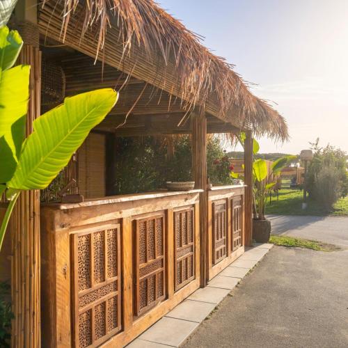 a building with a straw roof and a porch at NOMAD ARGENTARIO - Area Sosta Camper - NO TENDE - NO CARAVAN - Empty Pitch Only Campervan RV - SOLO PIAZZOLA PER IL PROPRIO CAMPER - Tariffa fino a 4 persone - TUTTI I SERVIZI INCLUSI in Albinia