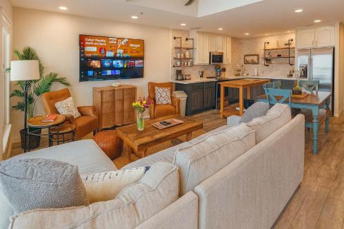 a living room with a couch and a kitchen at Penthouse Beachfront Views Renovated condo in South Padre Island