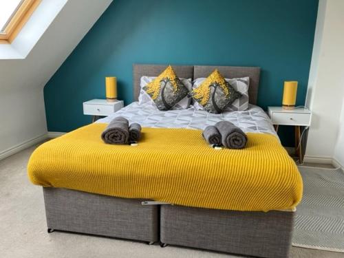 a bedroom with a large bed with a yellow blanket at Spring House - Staycation - Perfect for Contractors & Families - 2 Parking Spaces in Dudley