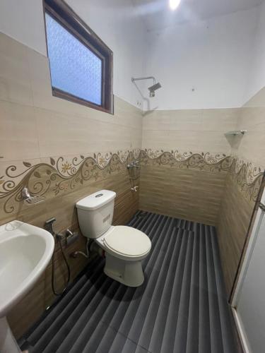 a bathroom with a toilet and a tub and a sink at saffronvilla in Haputale