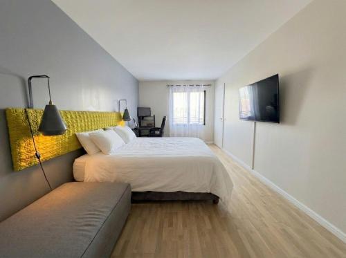 a bedroom with a large bed and a couch at Big Flat - Direct CERN in Saint-Genis-Pouilly