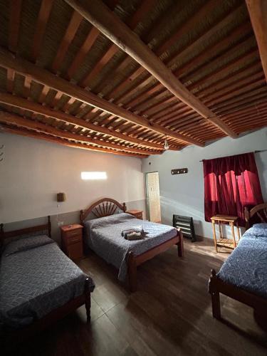 a bedroom with two beds and a wooden ceiling at Hospedaje Don Carmelo in El Peñón
