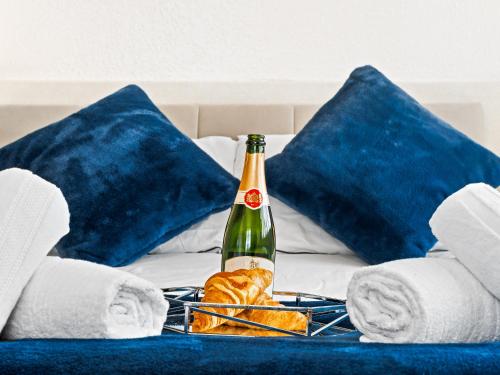 a bottle of champagne and towels on a bed at Rising Sun in Rogerstone