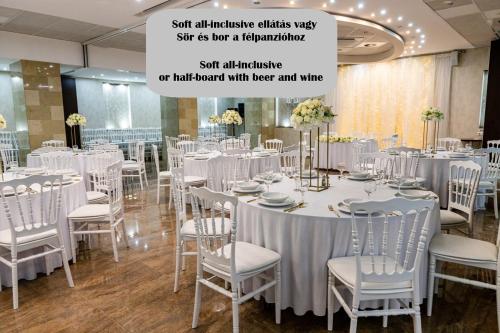 a room with tables and chairs with white tablecloths at Bástya Konferencia és Wellness Hotel in Miskolctapolca
