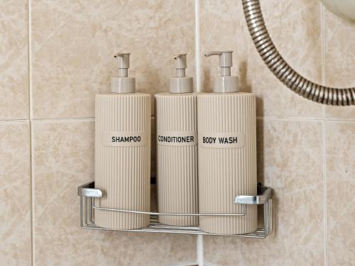 a rack with three soap dispensers in a bathroom at Rising Sun in Rogerstone