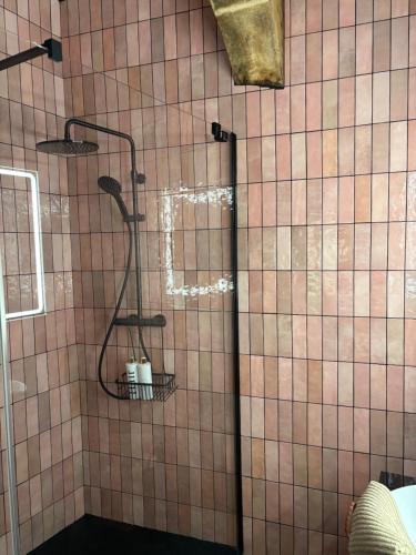 a shower in a bathroom with a tiled wall at 3 Doni in Rabat