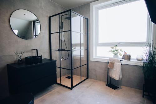 a bathroom with a shower and a sink and a mirror at Odda Apartments - 2BR & 3BR - Parking - T32 in Odda