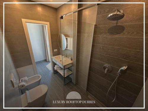 een badkamer met een douche, een toilet en een wastafel bij Mar' Rooftop Suites in Durrës