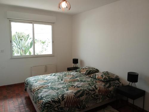 a bedroom with a bed and a window at Gite d'Ossau in Lescar
