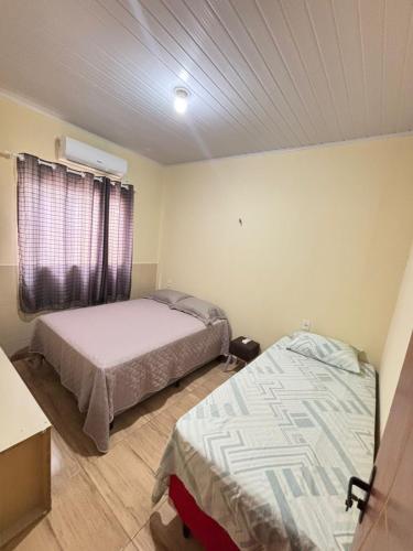 a room with two beds and a window in it at Apartamento Lençóis in Barreirinhas