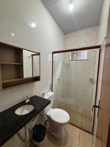 a bathroom with a toilet and a sink and a shower at Apartamento Lençóis in Barreirinhas