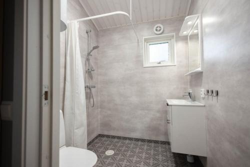 a bathroom with a shower and a toilet and a sink at Kapelludden Camping & Stugor in Borgholm