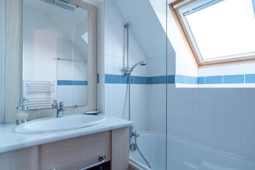 a bathroom with a sink and a glass shower at Pentrez Cottage - 600m de la Plage in Saint-Nic