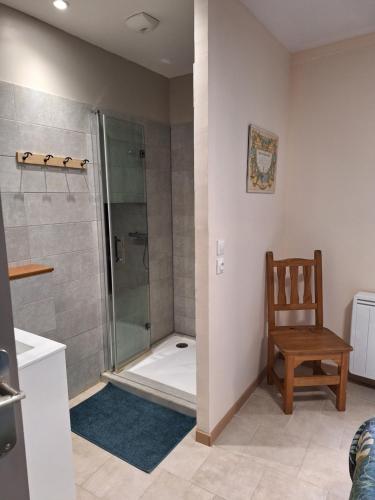 a bathroom with a shower and a wooden chair at Chez René in Montagnac