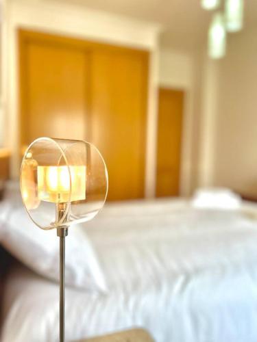 a bedroom with a bed with a lamp in front of it at Apartamento T2 com vista panorâmica sobre a costa in Atouguia da Baleia