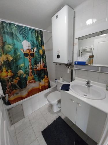 un bagno con lavandino, WC e tenda da doccia di Menton 1 a Mentone