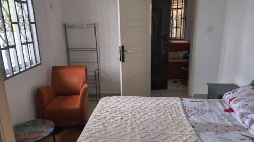 a bedroom with a bed and a chair and a door at Ivan John Guest home in Number Two Village