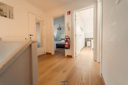 a room with a hallway with a red suitcase in it at Villa Promenade - luxuriously apartment for 8 people in Nieuwpoort