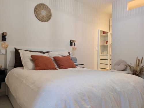 a bedroom with a large white bed with orange pillows at La Perle in Marseille