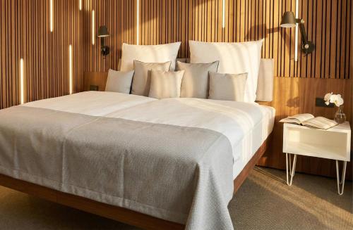 a large bed with white sheets and pillows at H24 Berlin Lichtenberg in Berlin