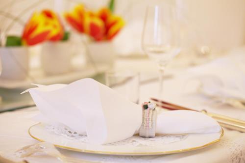 a plate with a napkin on a table with flowers at Hotel Sparerhof in Vilpiano