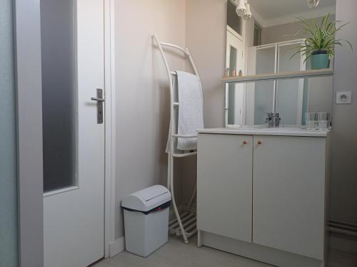 a bathroom with a sink and a chair in it at Un B&B à Loktudi in Loctudy