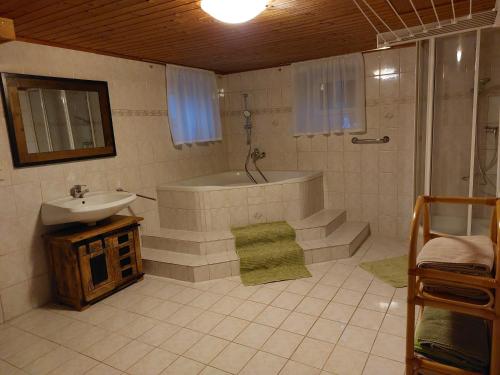 a bathroom with a tub and a sink and a shower at Ferienhaus Wohleser in Mariahof