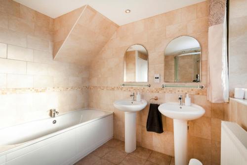 a bathroom with two sinks and a bath tub and a tubermott at Cedar Place in Southwell in Southwell