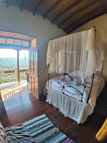 a bedroom with a canopy bed with a balcony at Archontikon 1817 in Kaliana