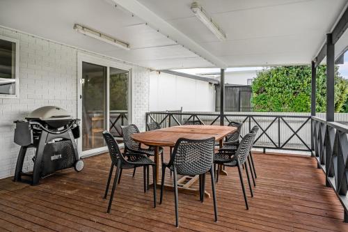 a table and chairs on a deck with a grill at Adrift - Oceanfront - Pets Welcome in Middleton