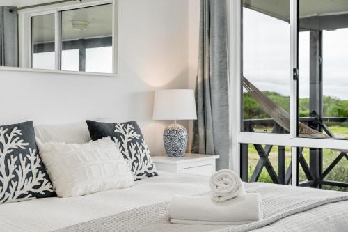 a bedroom with a bed and a large window at Adrift - Oceanfront - Pets Welcome in Middleton