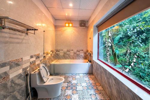 a bathroom with a toilet and an aquarium in the window at Chinh Thu Garden Retreat in Ninh Binh